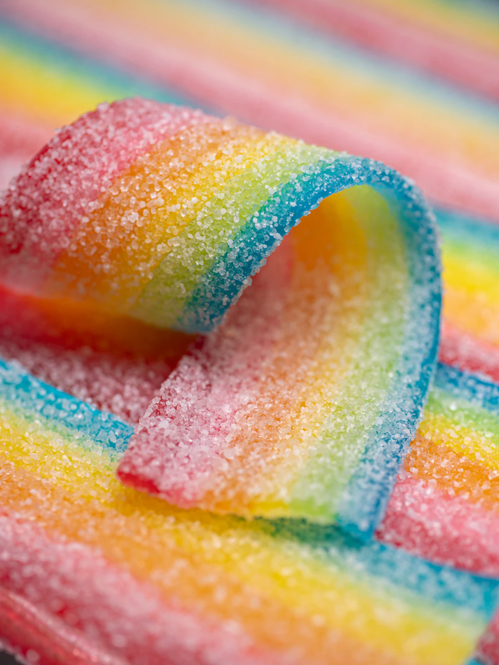 Sugar-coated rainbow sour candy seen close up